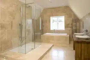 Entreprise de rénovation - Maison Beneva 11 large bathroom with glass enclosed shower travertine floors and double sink on wooden countertop is 1.jpg Entreprise de rénovation - Maison Beneva